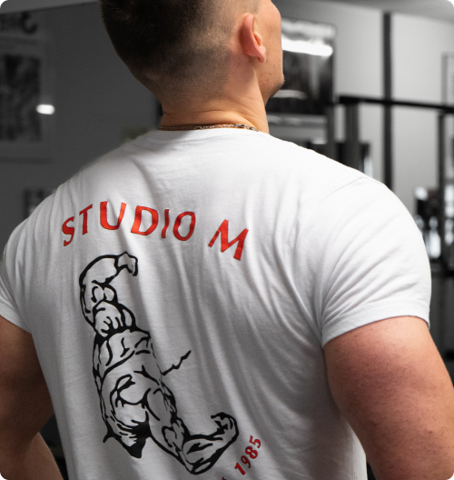 Studio M Rücken eines Bodybuilders mit T-Shirt des Studio M